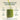 Glass of green juice with text about health benefits on a beige background