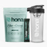 Hona Fiber + Greens package, single serving stick pack, and clear shaker bottle on a white background